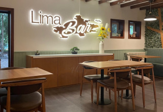 Interno di Lima Escape Glamping in Portogallo con tavoli in legno, sedie comode e moderna decorazione.