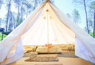 Interieur van een luxe glampingtent met tweepersoonsbed en gezellige inrichting bij Lima Escape, Portugal.