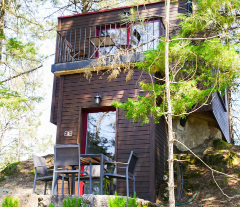 Treehouse glamping accommodation at Lima Escape in Portugal, surrounded by forest and outdoor seating.