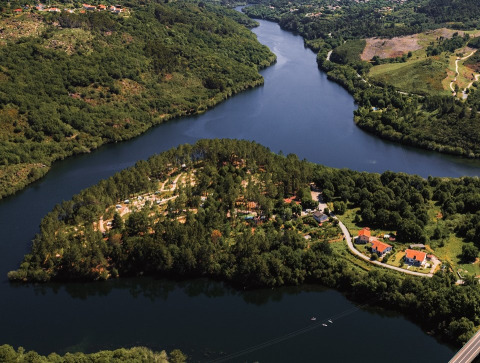 Vista aerea del glamping Lima Escape in Portogallo, immerso nella natura tra fiume, tende e lodge.