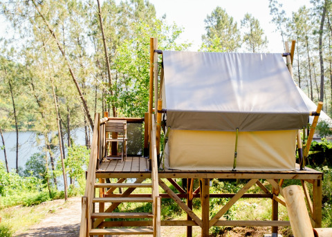Glamping-indkvartering med forhøjet teltplatform og udsigt over skov og sø ved Lima Escape i Portugal.