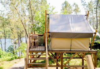 Glamping lodge on a raised wooden platform overlooking forest and lake at Lima Escape in Portugal.