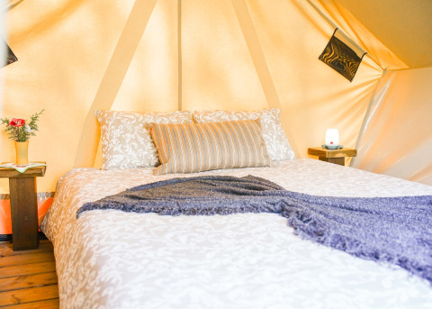 Knus bed in een luxe tent bij Lima Escape Boomlodges en Glamping tenten Portugal, sfeervolle inrichting.