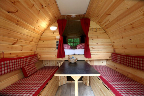 Interieur van een glamping accommodatie met houten wanden, banken en bed, Camping Isny - Luxe glamping Baden-Württemberg.
