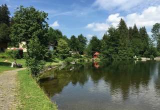 Camping Isny - Luxe glamping Baden-Württemberg met een idyllisch meer, groene bomen en rustige sfeer.
