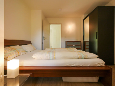 Lichte en moderne slaapkamer met comfortabel bed op Camping Isny - Luxe glamping Baden-Württemberg locatie.