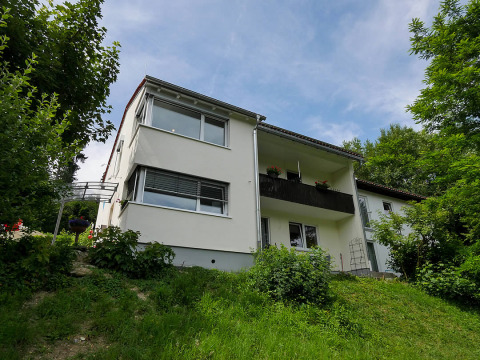 Alloggio glamping bianco al Camping Isny di Baden-Württemberg, immerso nel verde rigoglioso.