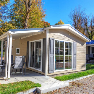 Cabaña glamping moderna en Camping Pilsensee - Stacaravans Beieren rodeada de árboles y naturaleza.
