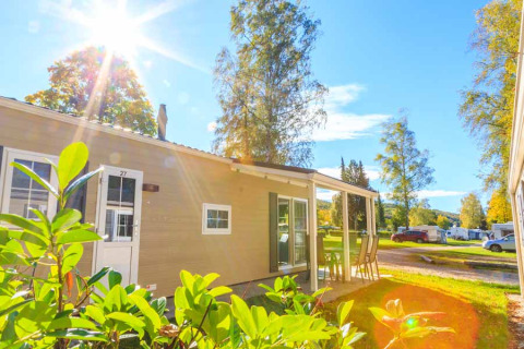 Sunny day at Camping Pilsensee - Stacaravans Beieren, glamping accommodation with patio and green surroundings.