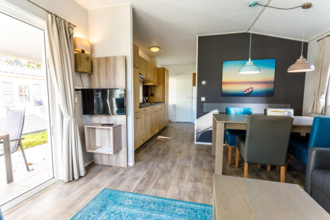 Moderne glampingindkvartering med åbent opholdsområde og spisebord på Camping Pilsensee - Stacaravans Beieren.