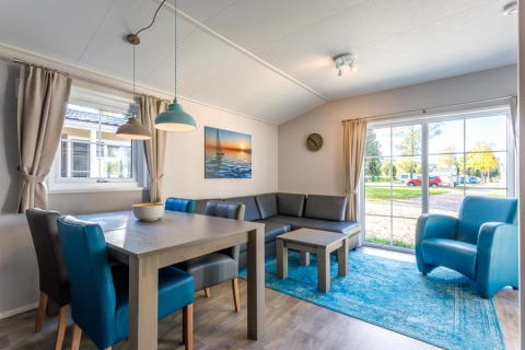 Modern living room in glamping accommodation at Camping Pilsensee - Stacaravans Beieren with blue decor.