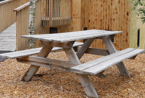 Wooden picnic table at Boomhutpark Voglsam - Boomhutten Beieren glamping accommodation in a natural setting