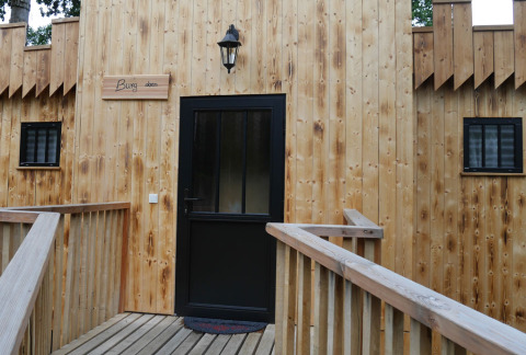 Glamping accommodation with wooden facade and black door at Boomhutpark Voglsam in Bavaria.