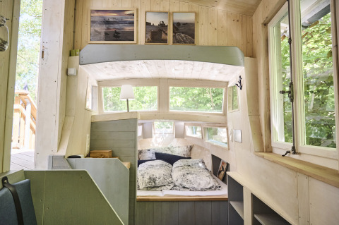 Vista interior de Baumschiffhotel Boomschepen Beieren, espacio glamping acogedor con cama grande y ventanas.
