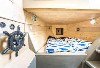 Sfeervol bootvormig bed in Baumschiffhotel - Boomschepen Beieren glamping met maritieme aankleding.