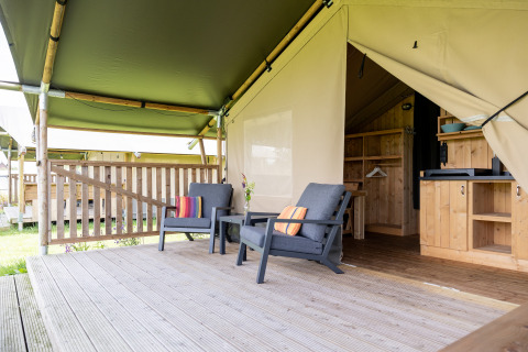 Tente safari de glamping avec terrasse, sièges et coin cuisine au Camping Natuurlijk de Veenhoop, en Frise.