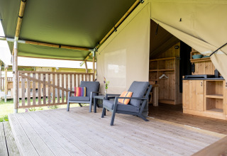 Tienda de glamping safari con terraza, sillas y cocina en Camping Natuurlijk de Veenhoop, Friesland, Países Bajos.