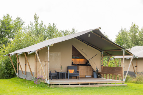 Glamping-indkvartering i safaritelt ved Camping Natuurlijk de Veenhoop i Friesland, Holland, omgivet af grøn natur.