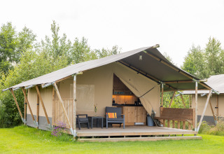 Luxe safaritent glamping op Camping Natuurlijk de Veenhoop in Friesland, Nederland, met gezellige veranda.