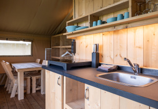 Kitchen and dining area interior in a luxury safari tent at Camping Natuurlijk de Veenhoop, Friesland.