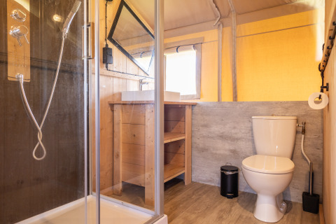 Baño moderno en Camping Natuurlijk de Veenhoop - Safaritenten Friesland con ducha, inodoro y lavabo visibles.