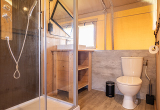 Moderne badkamer bij Camping Natuurlijk de Veenhoop - Safaritenten Friesland met douche en toilet zichtbaar.