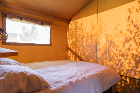 Interieur van glamping accommodatie met tweepersoonsbed bij Camping Natuurlijk de Veenhoop – Safaritenten Friesland.