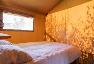 Gemütliches Glamping-Zelt mit Doppelbett bei Camping Natuurlijk de Veenhoop – Safaritenten Friesland exponiert.