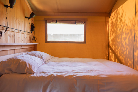 Gezellig bed in een safaritent bij Camping Natuurlijk de Veenhoop, ideaal voor glamping in Friesland.