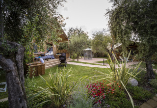 Glamping at Weekend Glamping Resort near Lake Garda, featuring a safari tent, deck, and lush garden.