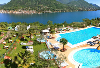 Vista del Weekend Glamping Resort junto al Lago de Garda, con piscinas, jardines y paisajes impresionantes.
