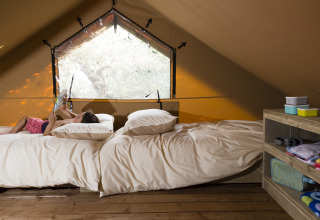 Bambino rilassato in tenda safari al Weekend Glamping Resort sul Lago di Garda, Italia.