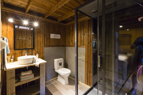 Baño rústico con paredes de madera, ducha moderna y lavabo en Weekend Glamping Resort Lago de Garda.