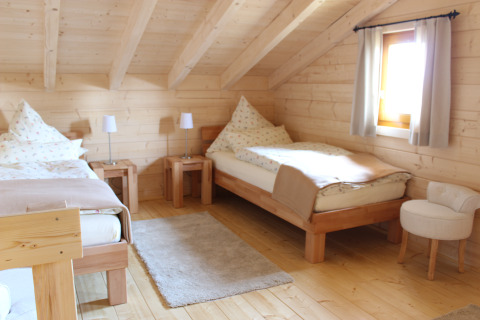 Interior de una acogedora cabaña de madera con dos camas individuales en Höhencamping Königskanzel, Selva Negra.