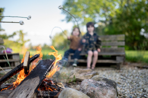 Kinder rösten Marshmallows am Lagerfeuer bei Uitstek - Tiny Houses Drenthe, umgeben von Natur.