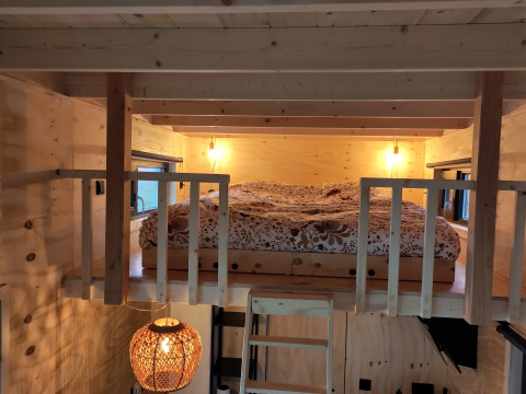Knusse slaapvide met houten interieur en warme verlichting bij glamping Uitstek - Tiny Houses Drenthe.