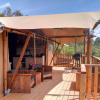 Casa da Vinha glamping lodge in Alentejo featuring a wooden terrace, seating, swing, and scenic field views.
