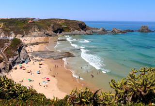 Plage de sable entourée de rochers et eaux claires près de Casa da Vinha - Glamping Lodges en Alentejo.