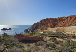 Paysage côtier avec épave de bateau et falaises près de Casa da Vinha - Glamping Lodges en Alentejo, Portugal.