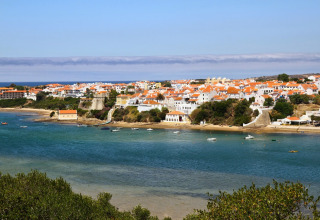 Charmerende udsigt over landsby med røde tage ved havet nær Casa da Vinha - Glamping Lodges i Alentejo.
