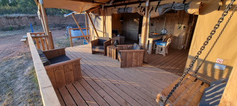 Veranda di Casa da Vinha - Glamping Lodges in Alentejo con arredi in legno e panca a dondolo.