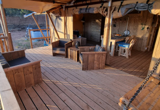 Veranda di Casa da Vinha - Glamping Lodges in Alentejo con arredi in legno e panca a dondolo.