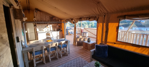 Alojamiento glamping Casa da Vinha en Alentejo, interior de lona acogedor con terraza de madera al sol.