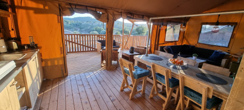 Vue intérieure de Casa da Vinha Glamping Lodges en Alentejo avec terrasse en bois et coin repas.