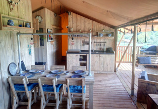 Vue intérieure du lodge glamping Casa da Vinha en Alentejo avec meubles en bois et cuisine ouverte.