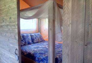 Accogliente alloggio glamping con porta in legno e letto a baldacchino a Casa da Vinha - Glamping Lodges in Alentejo.