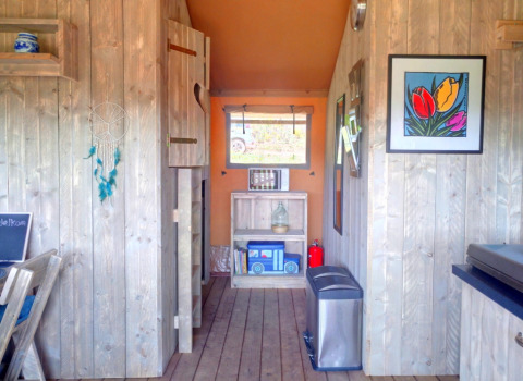 Interno accogliente di Casa da Vinha Glamping Lodge in Alentejo con pareti di legno e decorazioni vivaci.