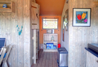 Knus interieur van Casa da Vinha glamping lodge in Alentejo met houten wanden, kleurige kunst en details.