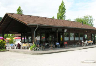 Camping Axelsee - Bungalow in legno a Renania Settentrionale con area esterna e ombrelloni colorati.