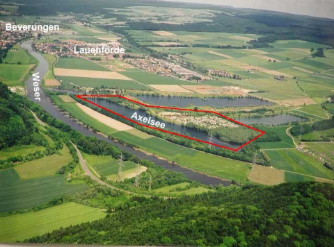 Luftaufnahme von Camping Axelsee - Blokhutten Noordrijn-Westfalen am Ufer der Weser in grüner Landschaft.